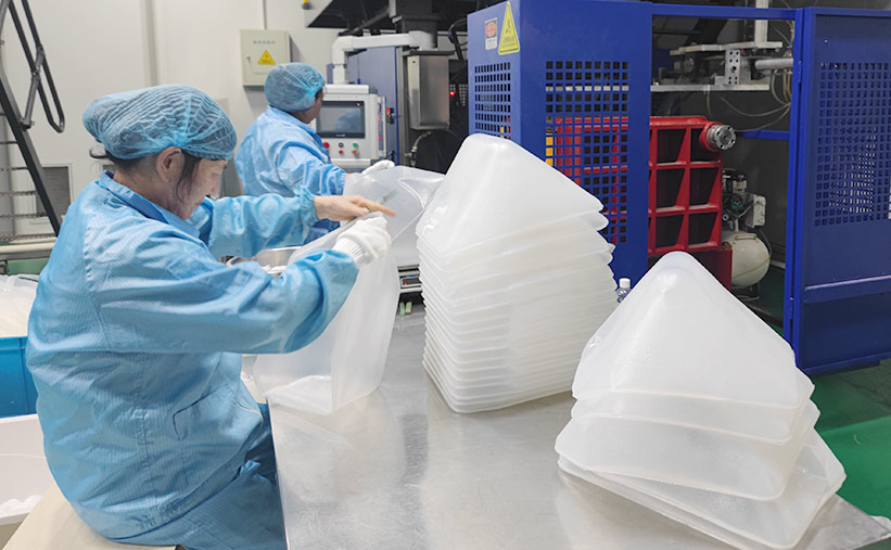 Workers producing cubitainers in LIQPACK clean production workshop